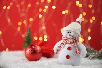 Cute decorative snowman on artificial snow. Space for text