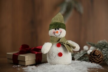 Cute decorative snowman and other Christmas decor on wooden table