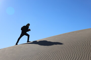 person walking on the sand dune