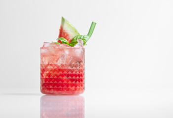 Glass of refreshing watermelon smoothie with basil, ice on white isolated background with shadow close up.