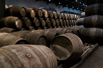 Wine cellar, row of wooden barrels close up