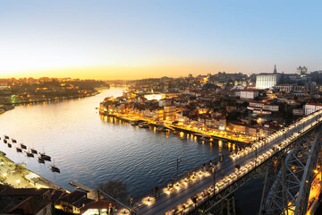 Obraz premium Picturesque, colorful view at old town Porto with famous bridge at night, Portugal with bridge Ponte Dom Luis over Douro river. Oporto, touristic mediterranean city