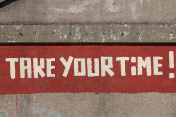 Take your time reminder painted on old wall