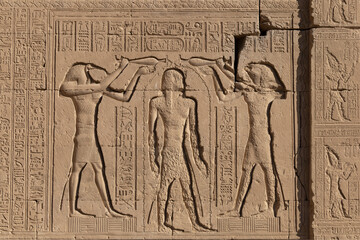 Sunk reliefs represents the Baptism of Pharaoh at Hathor temple. Qena. Egypt.