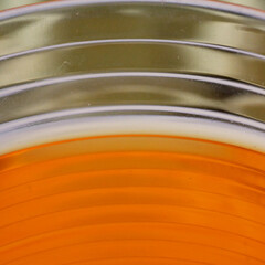 glass filled half with orange colored liquid water