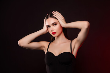 Fototapeta premium Photo of lady in black evening gown touch brown hair isolated dark color background