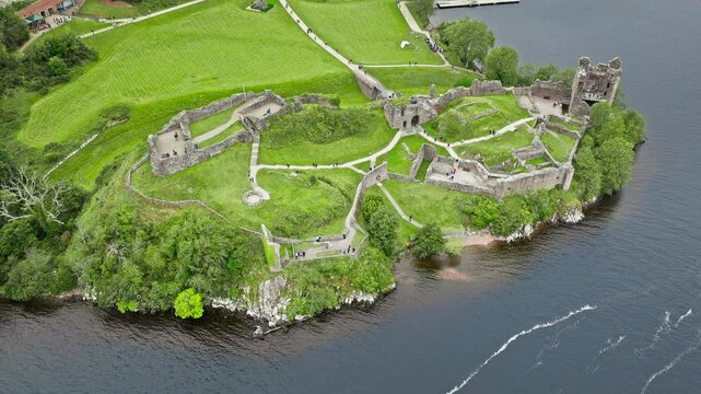 Aerial view of Urquhart Castle Large, ruined castle overlooking Loch Ness. The fortress situated on a headland, medial ruin in the Scottish Highlands laid out around two main enclosures on the shore.