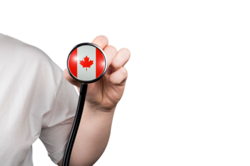 The head of a medical stethoscope in the form of the Canadian flag in a hand (close-up) on a transparent background. Canada's healthcare system concept