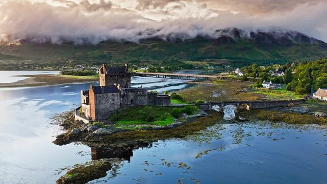 Aerial view of a rainbow over Eilean Donan Castle with long arched bridge and lochside setting. Scottish icon and a popular tourist attraction in the Highlands overlooking the Isle of Skye. 