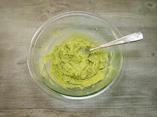 One mashed avocado in a glass bowl. Guacamole recipe.