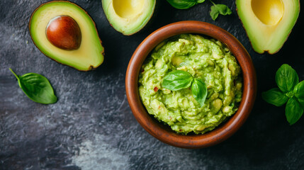 Top view of homemade guacamole in a bowl with avocados, ideal for food and culinary themes.