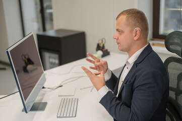Caucasian deaf man uses sign language for online negotiations.