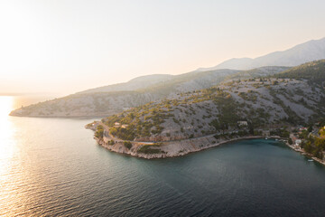 Fototapeta premium Breathtaking aerial view of a serene coastal landscape during golden hour near a tranquil bay. 