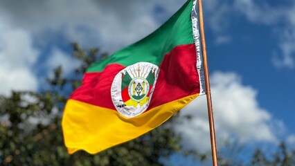 Flag of the State of Rio Grande do Sul waving in the wind on a nature background. Gaucho Flag. Week in the South of Brazil Farroupilha dos Gaúchos. © Marli
