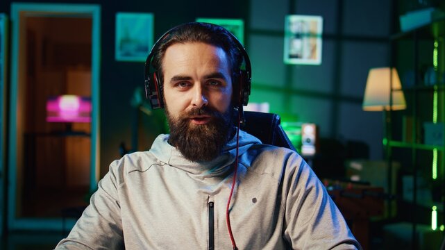 Esports player playing videogames in front of internet subscribers during livestream, providing engaging commentary while fighting foes. Zoom in shot of professional gamer streaming game