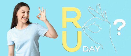 Young woman in stylish blue t-shirt showing OK on color background