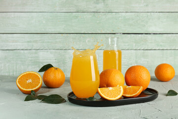 Glass of fresh orange juice with splashes on table