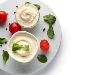 Bowls with tasty cream cheese on white background