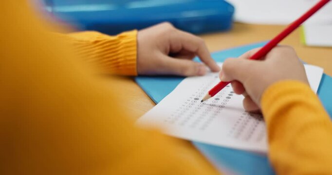 Education, hands and multiple choice with student at desk in classroom for assessment, development or learning. Exam, test or question and person in class with pencil to answer or select option