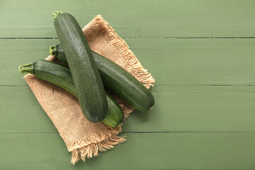 Many fresh zucchini on green wooden background