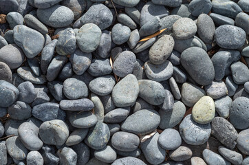 Black Rounded Stones on an Ocean Beach.