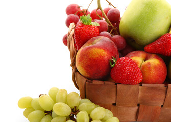 Wicker basket with different fresh fruits on white background, closeup