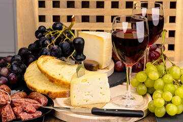 Calici di vino rosso con formaggio , salamini italiani , uva e pane 
