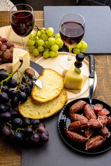 Calici di vino rosso con pane , formaggio , salamini italiani e uva 