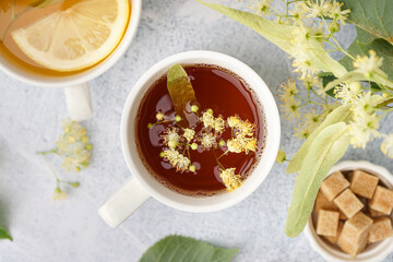 Cups of linden tea with lemon on white background