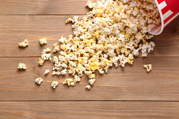 Bucket with tasty popcorn on wooden background