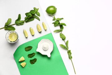Composition with fresh mint, lime and juicer on light background