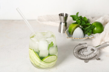 Glass of mojito with cucumber on grunge white background