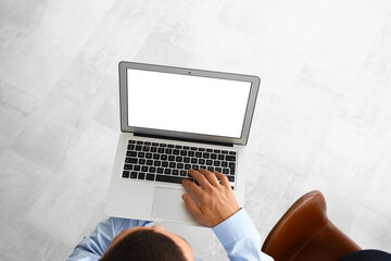 Fototapeta premium Businessman working with laptop in office, top view