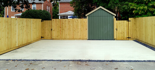 Newly constructed fence and concrete, parking area for residential home