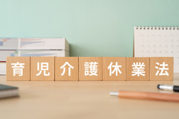 育児介護休業法の文字が入ったブロックが置かれたデスク