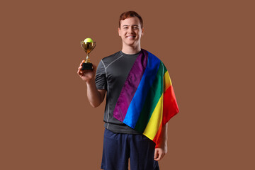Male tennis player with gold cup and LGBT flag on brown background