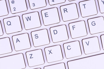 Close-up view of a white keyboard with black lettering on the keys. It could be relevant for topics related to technology, typing or computer hardware.