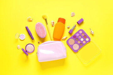 Beautiful composition with cosmetic bag, decorative cosmetics and sunscreen on yellow background