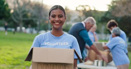 Portrait, happy woman and volunteer in nature with box, donation and contribution for community service. NGO, smile and female member in park with pride, charity and package for social responsibility
