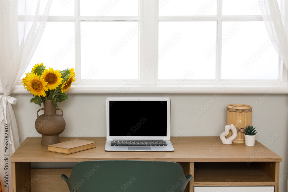 Poster Vase with sunflowers and blank laptop on table in room