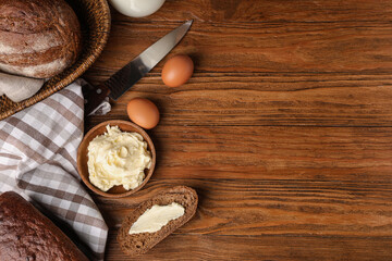 Composition with fresh butter, bread and chicken eggs on wooden background