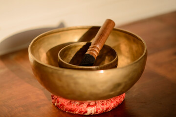 Cuencos tibetanos dorados sobre un cojín rojo la luz del atardecer