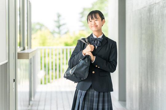 校舎の廊下を歩く制服姿の中学生・高校生の女の子
