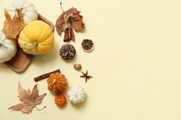 Autumn composition with candles, pumpkins and spices on color background