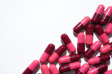 Pills, red medical capsules, antibiotic vitamins on a white background