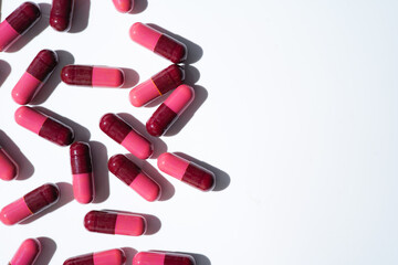 Pills, red medical capsules, antibiotic vitamins on a white background