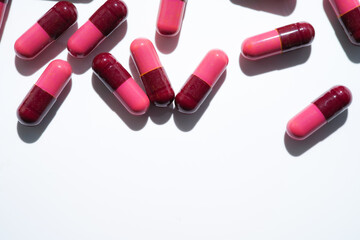 Pills, red medical capsules, antibiotic vitamins on a white background