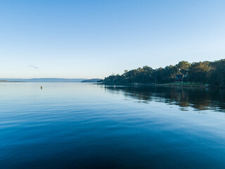 Still blue waters of coastal lake with buoy in water