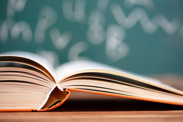 An open book in front of a blackboard