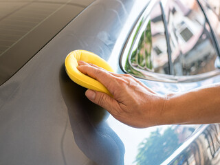 Man waxing a wax or polishing car, close up view. Car care concept.